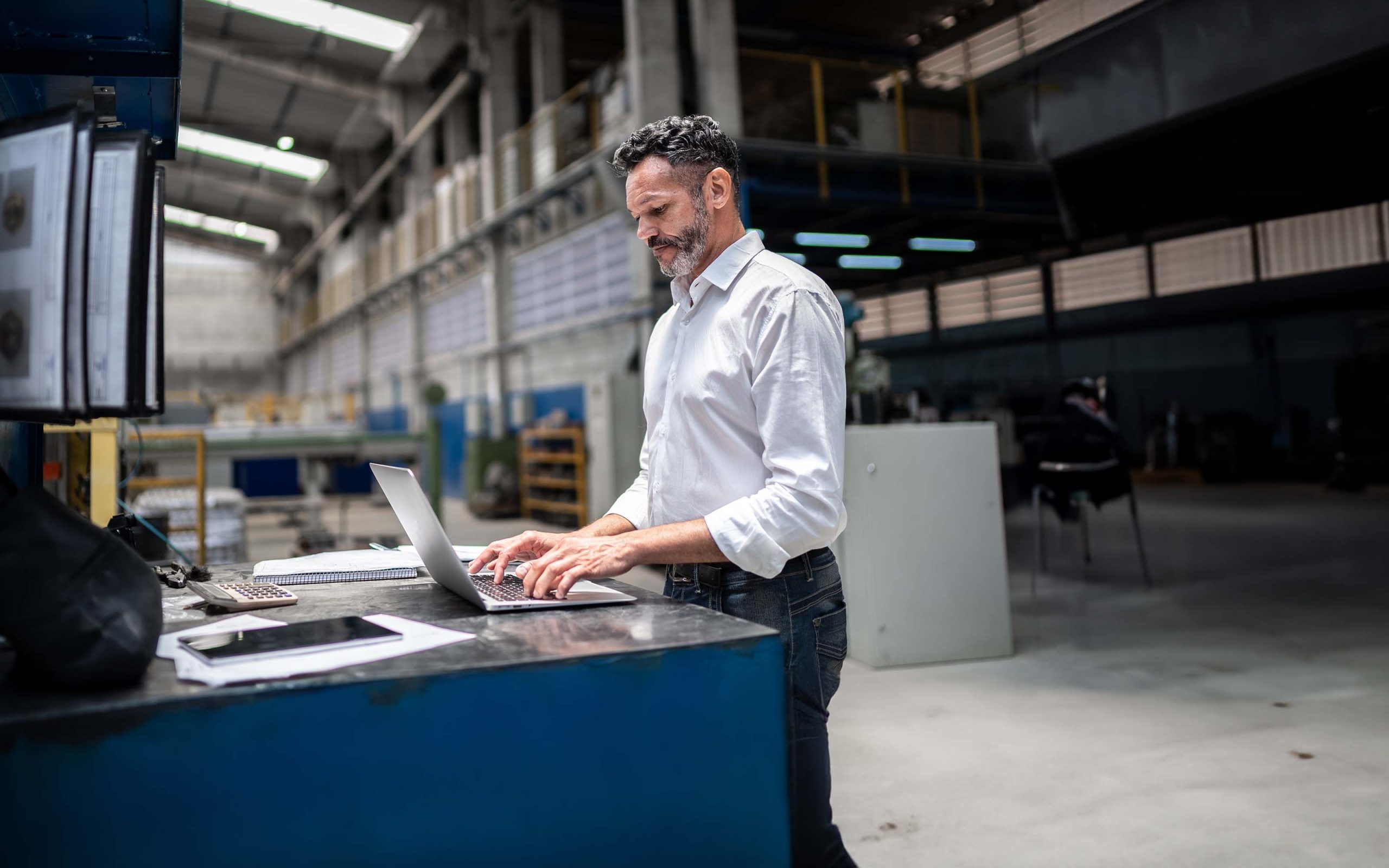 Businessman with a laptop in a factory